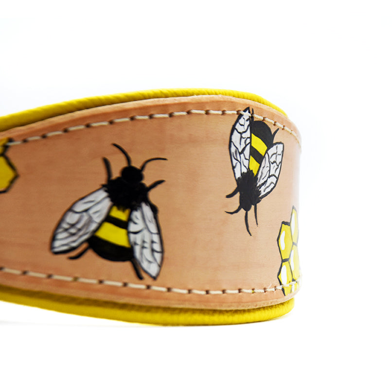 Detailaufnahme des Windhundhalsbands HONEYBEE aus Geschirrleder mit handbemalten Bienen und Waben auf naturfarbenem Leder.