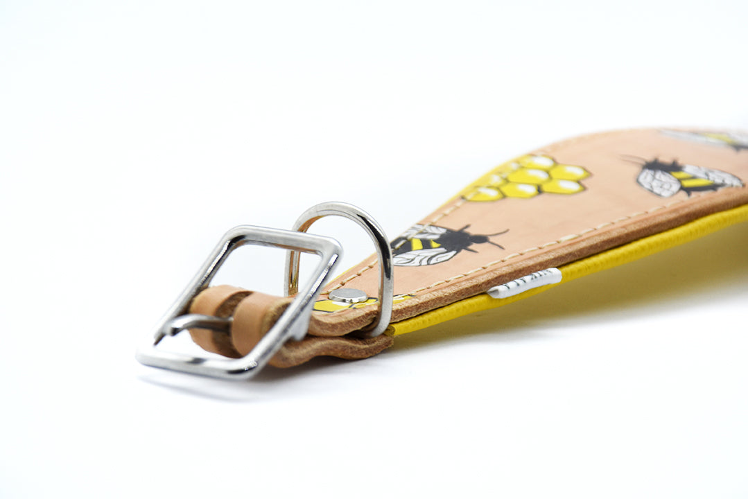 Nahaufnahme eines maßgefertigten Windhundhalsbands mit Bienen, Waben, gelbem Rand und aufwendig verarbeiteter Naht.